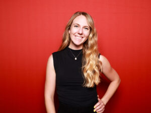 Katie Moser Stuck headshot on a red background